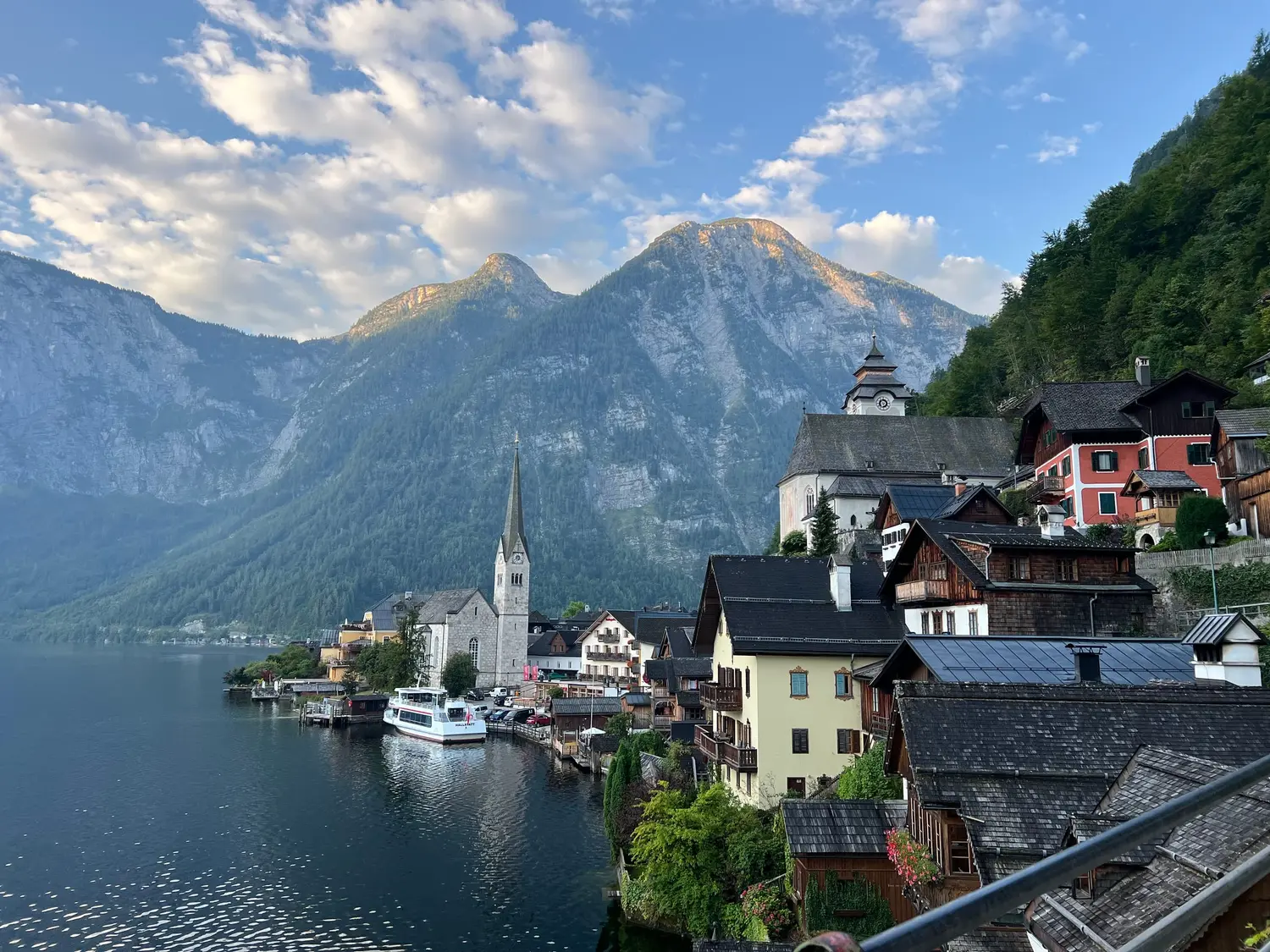 The classic view of Hallstatt with its church spire, lake and mountains at sunrise